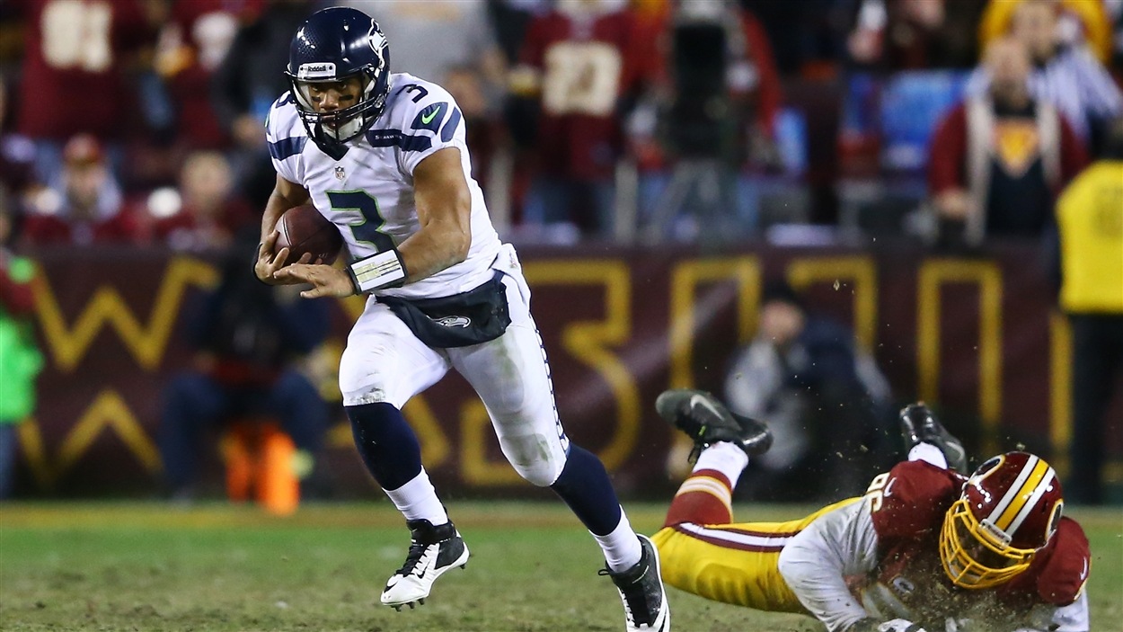 Le quart des Seahawks de Seattle Russell Wilson fait mordre la poussière à Barry Cofield des Redskins de Washington. Le quart des Seahawks de Seattle Russell Wilson fait mordre la poussière à Barry Cofield des Redskins de Washington.