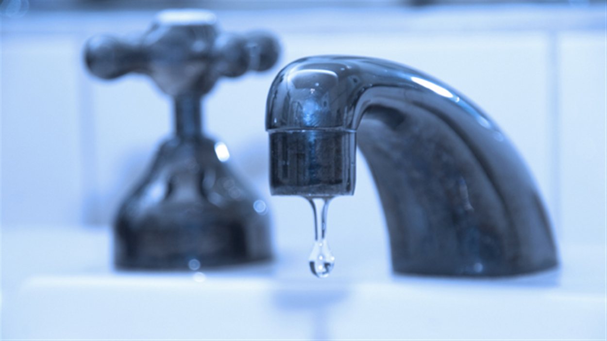 Un robinet coule dans un lavabo Un robinet coule dans un lavabo