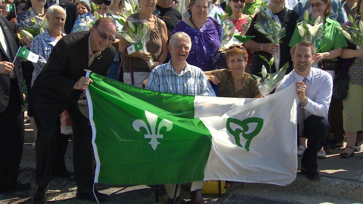 Le créateur du drapeau franco-ontarien, Gaétan Gervais (au centre), lors des célébrations de la Saint-Jean-Baptiste à Sudbury Le créateur du drapeau franco-ontarien, Gaétan Gervais (au centre), lors des célébrations de la Saint-Jean-Baptiste à Sudbury