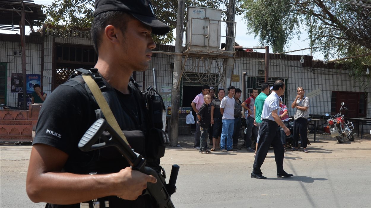 Un policier surveille la route empruntée mercredi par les émeutiers dans la ville de Lukqun, au Xinjiang. Un policier surveille la route empruntée mercredi par les émeutiers dans la ville de Lukqun, au Xinjiang.