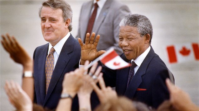 Nelson Mandela salue la foule lors de son arrivée à Ottawa le 17 juin 1990. Il est en compagnie du premier ministre Brian Mulroney. Nelson Mandela salue la foule lors de son arrivée à Ottawa le 17 juin 1990. Il est en compagnie du premier ministre Brian Mulroney.