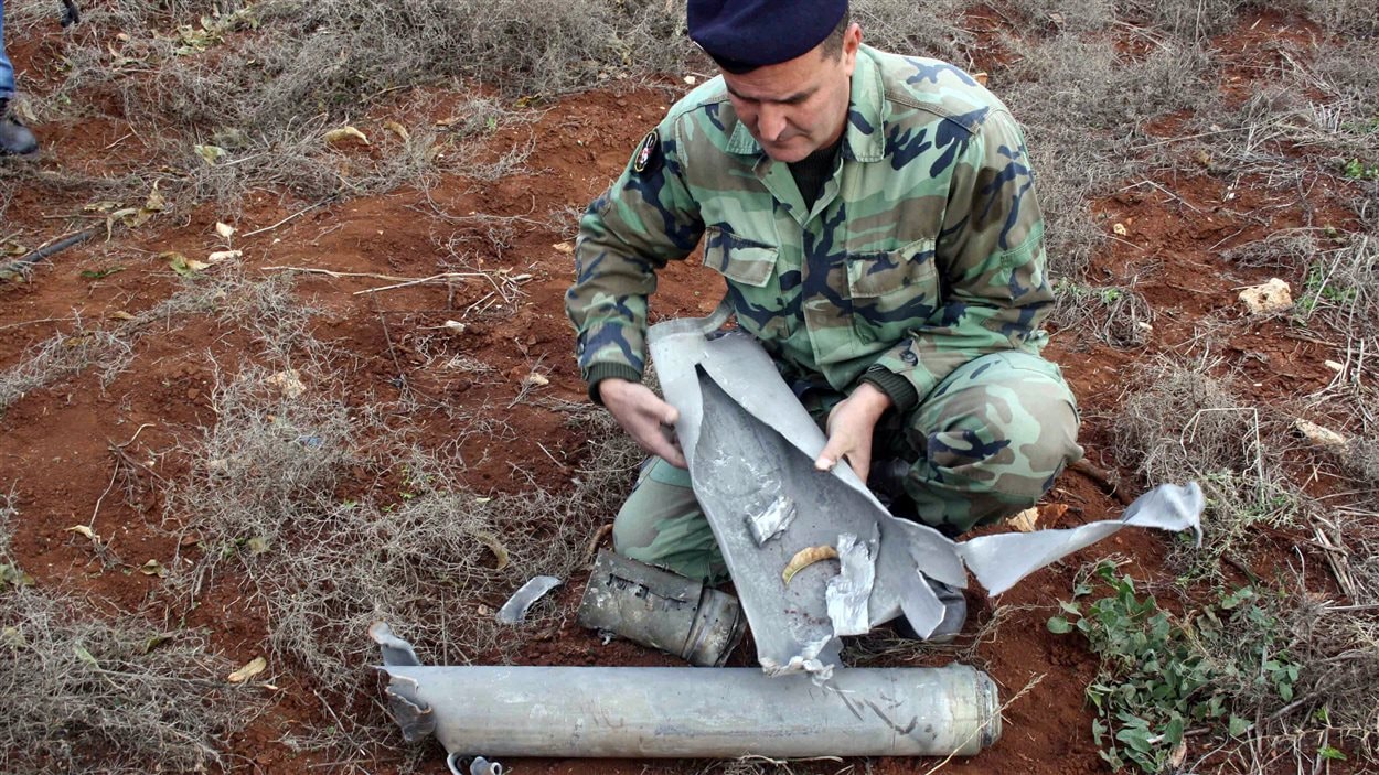 Un soldat libanais examine un des obus qui ont été tirés par l'armée israélienne dans le sud du Liban le 29 décembre 2013, sans causer de dommages. Un soldat libanais examine un des obus qui ont été tirés par l'armée israélienne dans le sud du Liban le 29 décembre 2013, sans causer de dommages.