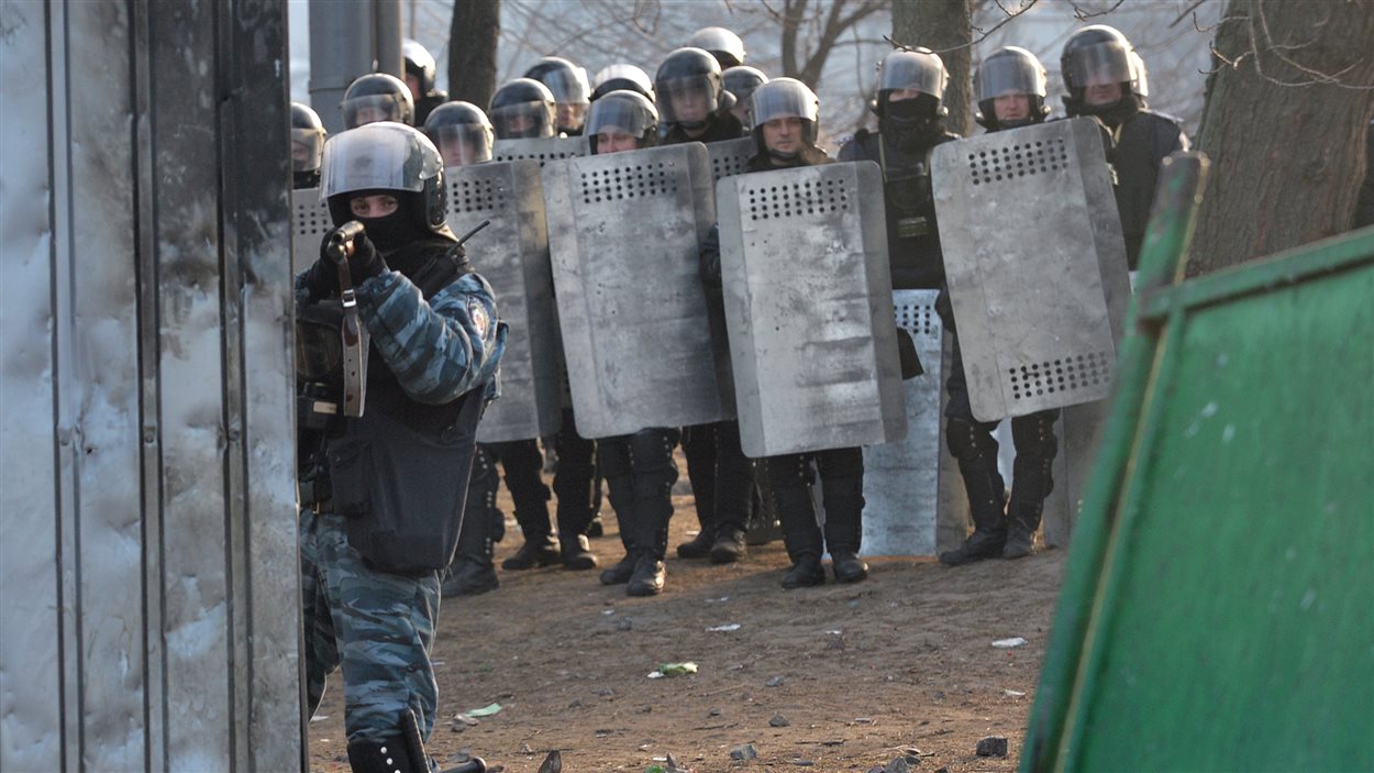 Un tireur d'élite ukrainien tient des manifestants en joue lors d'affrontements à Kiev. Un tireur d'élite ukrainien tient des manifestants en joue lors d'affrontements à Kiev.