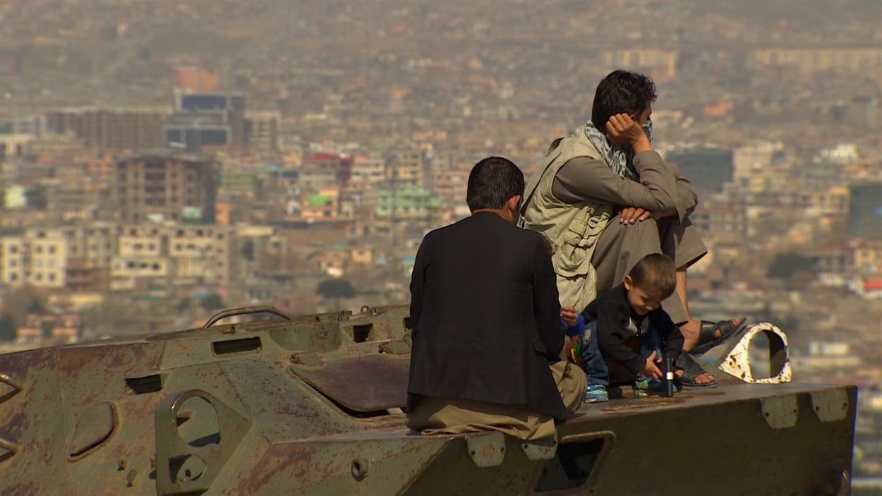 Des Afghans prennent une pause sur un vieux char d'assaut russe abandonné. Des Afghans prennent une pause sur un vieux char d'assaut russe abandonné.