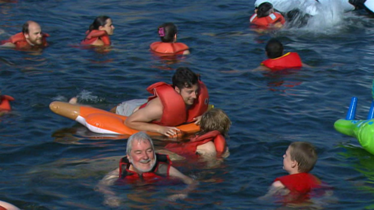 Des baigneurs heureux dans les eaux du Vieux-Port de Montréal. Des baigneurs heureux dans les eaux du Vieux-Port de Montréal.