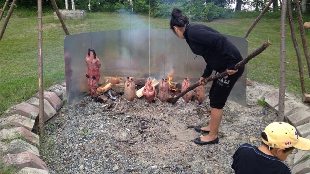 Vera Pien brasse la braise pendant la cuisson du gibier. Vera Pien brasse la braise pendant la cuisson du gibier.