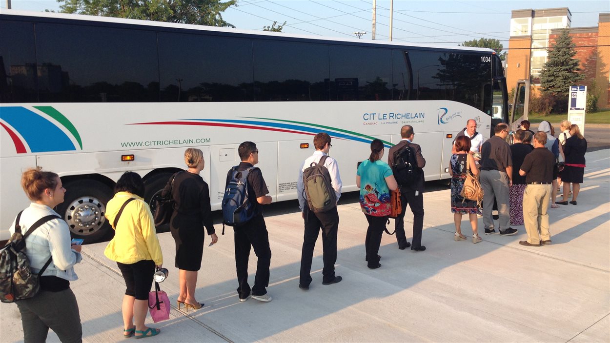 Des usagers embarquent dans un autobus au nouveau stationnement incitatif de Candiac Des usagers embarquent dans un autobus au nouveau stationnement incitatif de Candiac