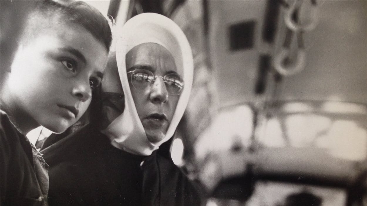 Lida Moser : Une religieuse accompagnant un jeune garçon dans un autobus, à Montréal, été 1950, gélatine argentique, 17,6 x 18 cm (P728,DM3,P96) Lida Moser : Une religieuse accompagnant un jeune garçon dans un autobus, à Montréal, été 1950, gélatine argentique, 17,6 x 18 cm (P728,DM3,P96)