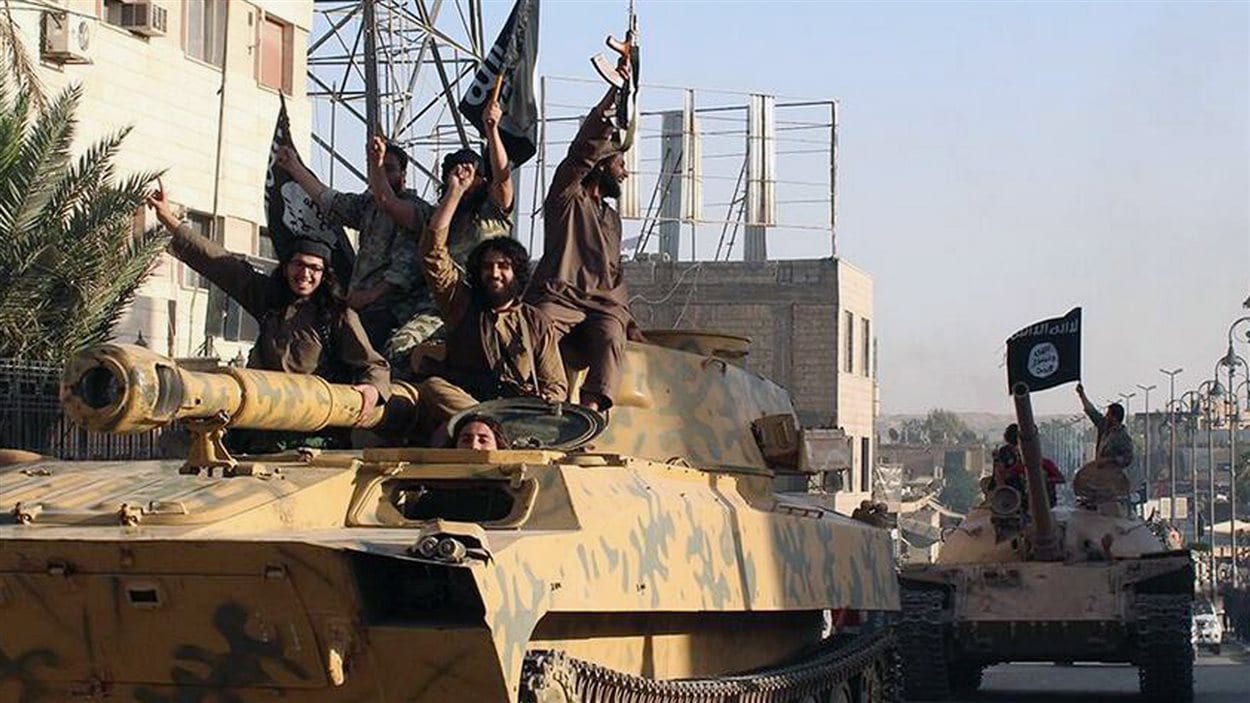 Photo d'un défilé de djihadistes à Raqqa, en Syrie, envoyée aux médias en juin 2014 par l'État islamique Photo d'un défilé de djihadistes à Raqqa, en Syrie, envoyée aux médias en juin 2014 par l'État islamique