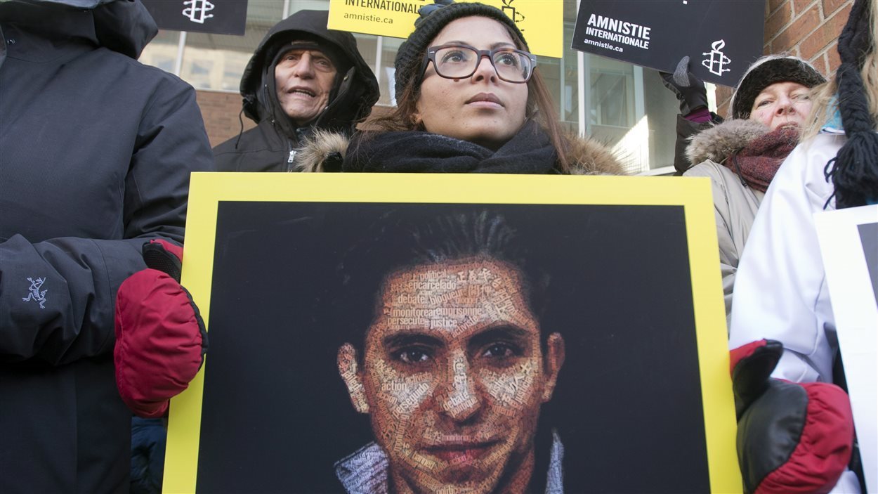 La femme de Raif Badawi, Ensaf Haidar, tient une photo de son mari lors d'une manifestation pour demander sa libération le 13 janvier 2015, à Montréal. La femme de Raif Badawi, Ensaf Haidar, tient une photo de son mari lors d'une manifestation pour demander sa libération le 13 janvier 2015, à Montréal.