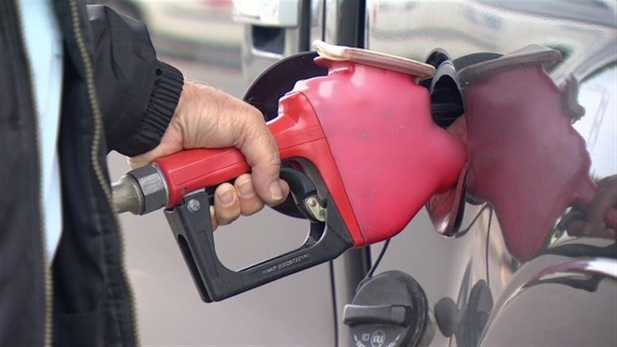 Un automobiliste fait le plein d'essence. Un automobiliste fait le plein d'essence.