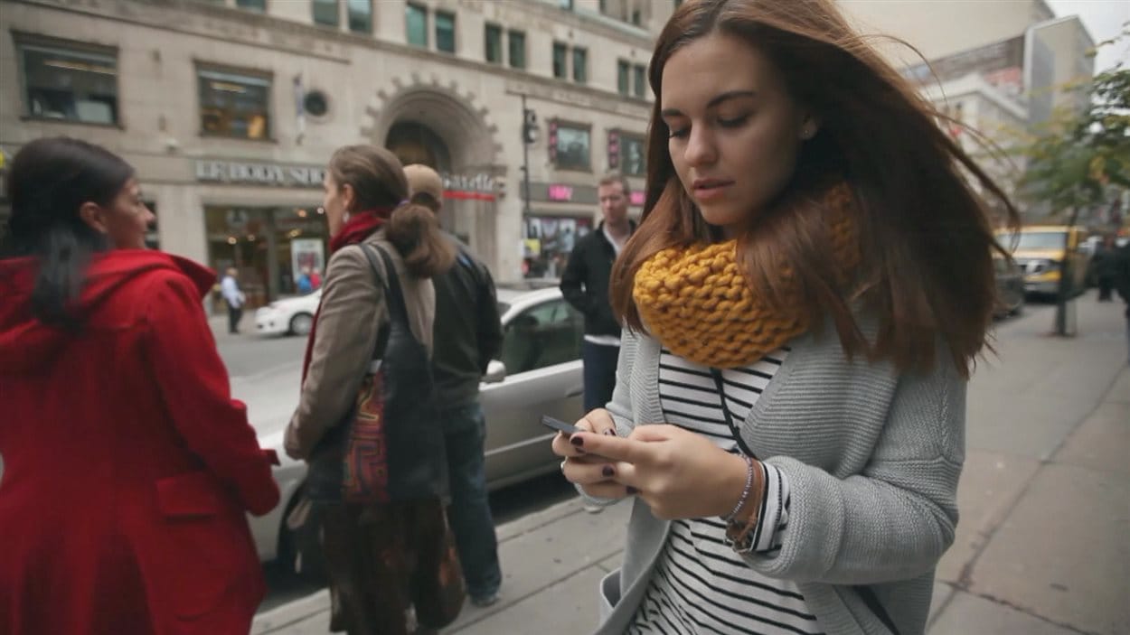 Une jeune femme texte en marchant Une jeune femme texte en marchant