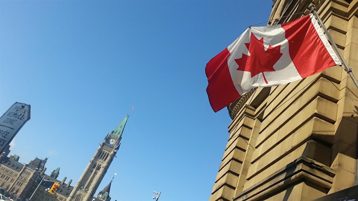 Le drapeau canadien flotte sur un édifice devant la colline du Parlement, à Ottawa, le 6 février 2015. Le drapeau canadien flotte sur un édifice devant la colline du Parlement, à Ottawa, le 6 février 2015.