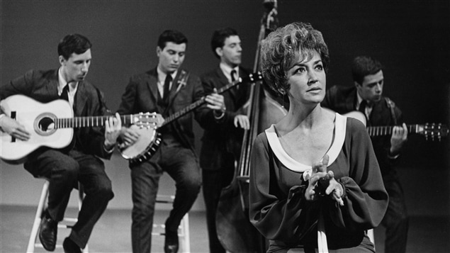 La chanteuse Lucille Dumont durant une prestation accompagnée par les musiciens du groupe les Quatre-Vingts, en 1965. La chanteuse Lucille Dumont durant une prestation accompagnée par les musiciens du groupe les Quatre-Vingts, en 1965.