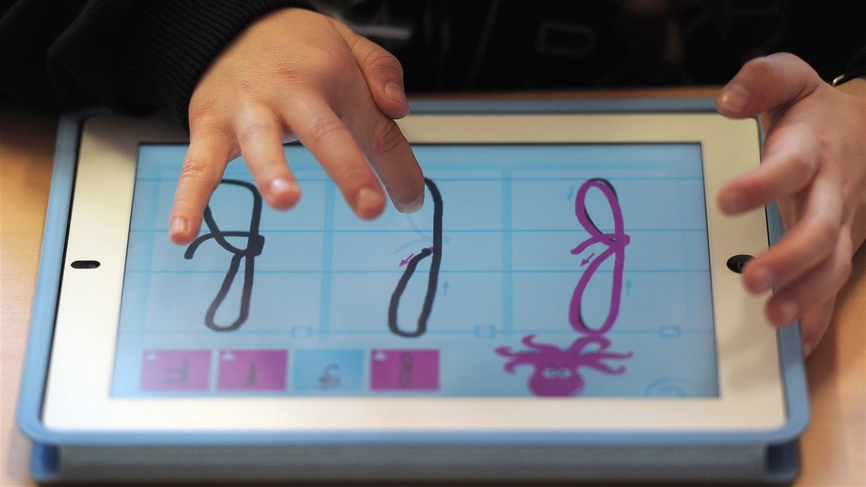Un enfant apprend l'alphabet avec une tablette. Un enfant apprend l'alphabet avec une tablette.