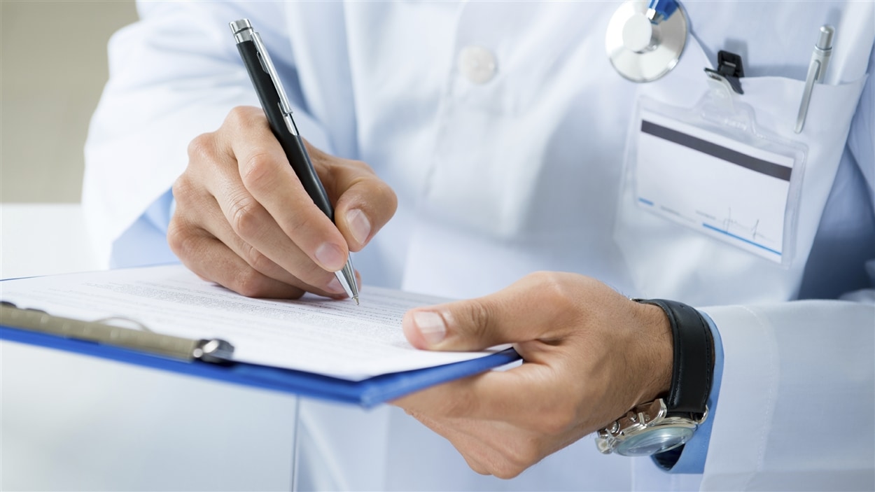 Un médecin remplit une fiche médicale. Un médecin remplit une fiche médicale.
