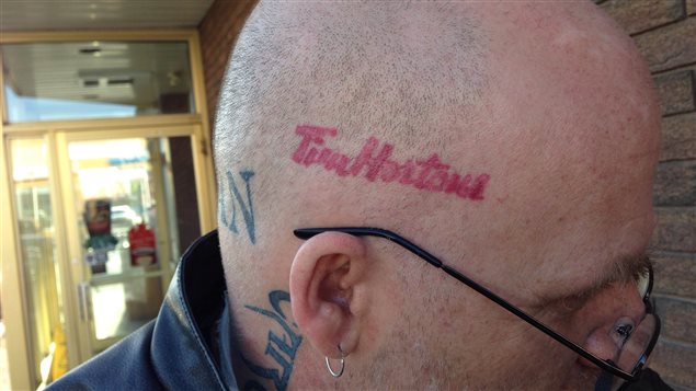 Korby Regan arbore un tatouage du logo de la chaîne de cafés Tim Hortons sur sa tête. Korby Regan arbore un tatouage du logo de la chaîne de cafés Tim Hortons sur sa tête.