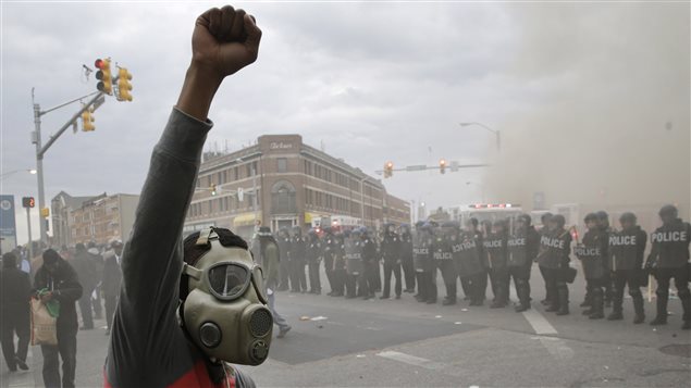 Les policiers et un manifestant avec un masque à gaz Les policiers et un manifestant avec un masque à gaz