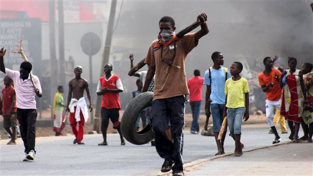 Un manifestant transporte un pneu pour ériger une barrière, lors d'une manifestation contre le dépôt de la nouvelle candidature du président sortant du Burundi. Un manifestant transporte un pneu pour ériger une barrière, lors d'une manifestation contre le dépôt de la nouvelle candidature du président sortant du Burundi.