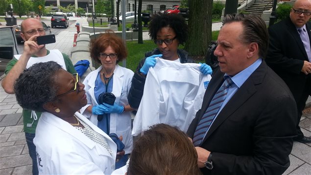 Le chef de la CAQ discute avec la présidente de la FIQ, Régine Laurent. Le chef de la CAQ discute avec la présidente de la FIQ, Régine Laurent.