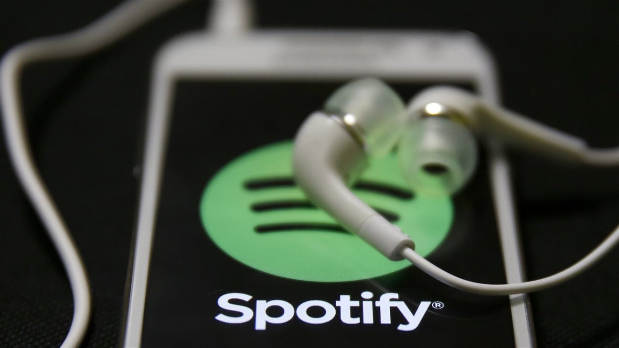 Des écouteurs et un téléphone intelligent branchés sur l'application Spotify Des écouteurs et un téléphone intelligent branchés sur l'application Spotify