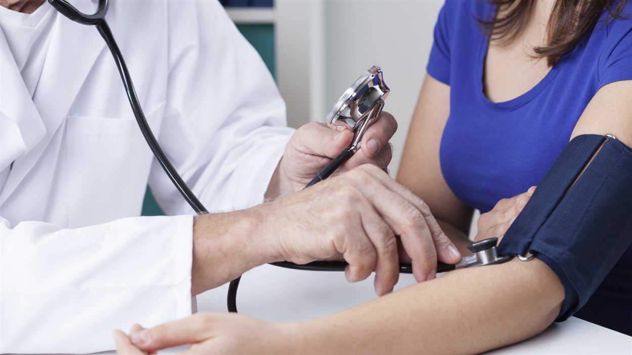 Un médecin mesure la pression artérielle d'une patiente. Un médecin mesure la pression artérielle d'une patiente.