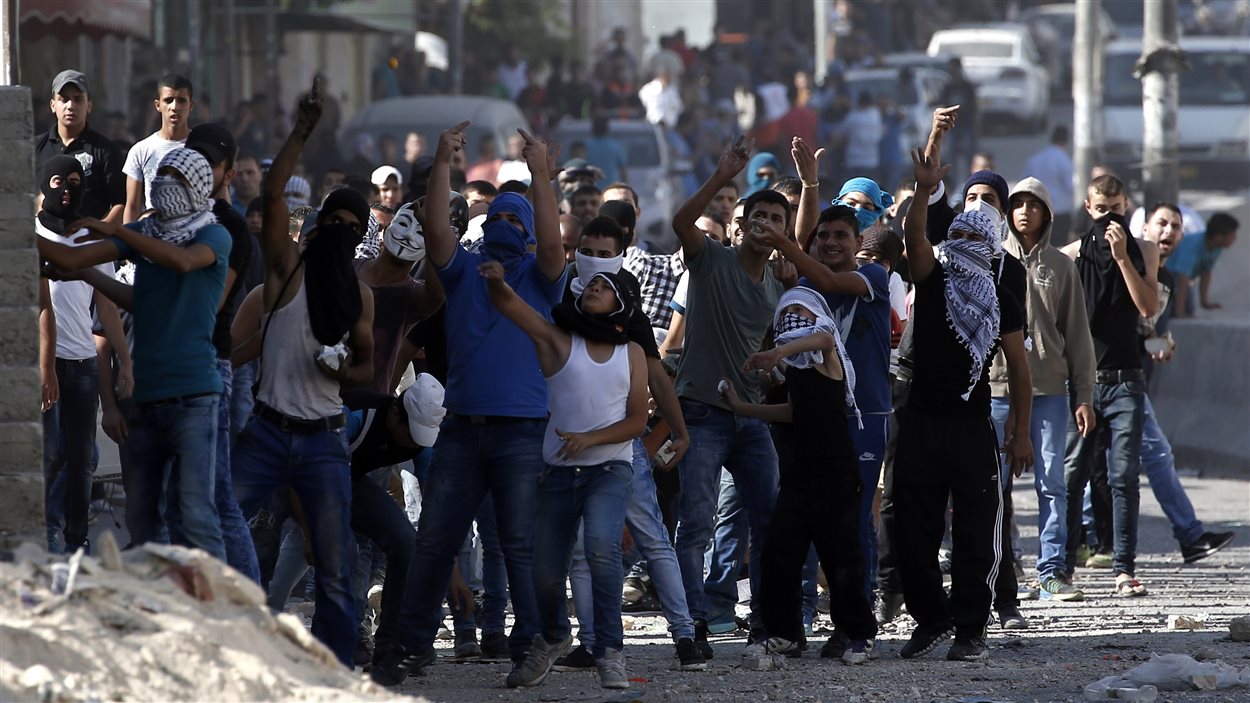 Des Palestiniens lancent des pierres à des soldats israéliens au point de passage de Qalandia, qui sépare Jérusalem de la Cisjordanie. Des Palestiniens lancent des pierres à des soldats israéliens au point de passage de Qalandia, qui sépare Jérusalem de la Cisjordanie.