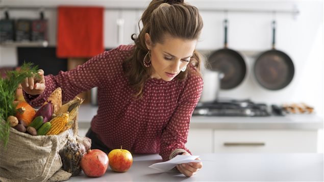 Un femme consulte sa facture d'épicerie Un femme consulte sa facture d'épicerie