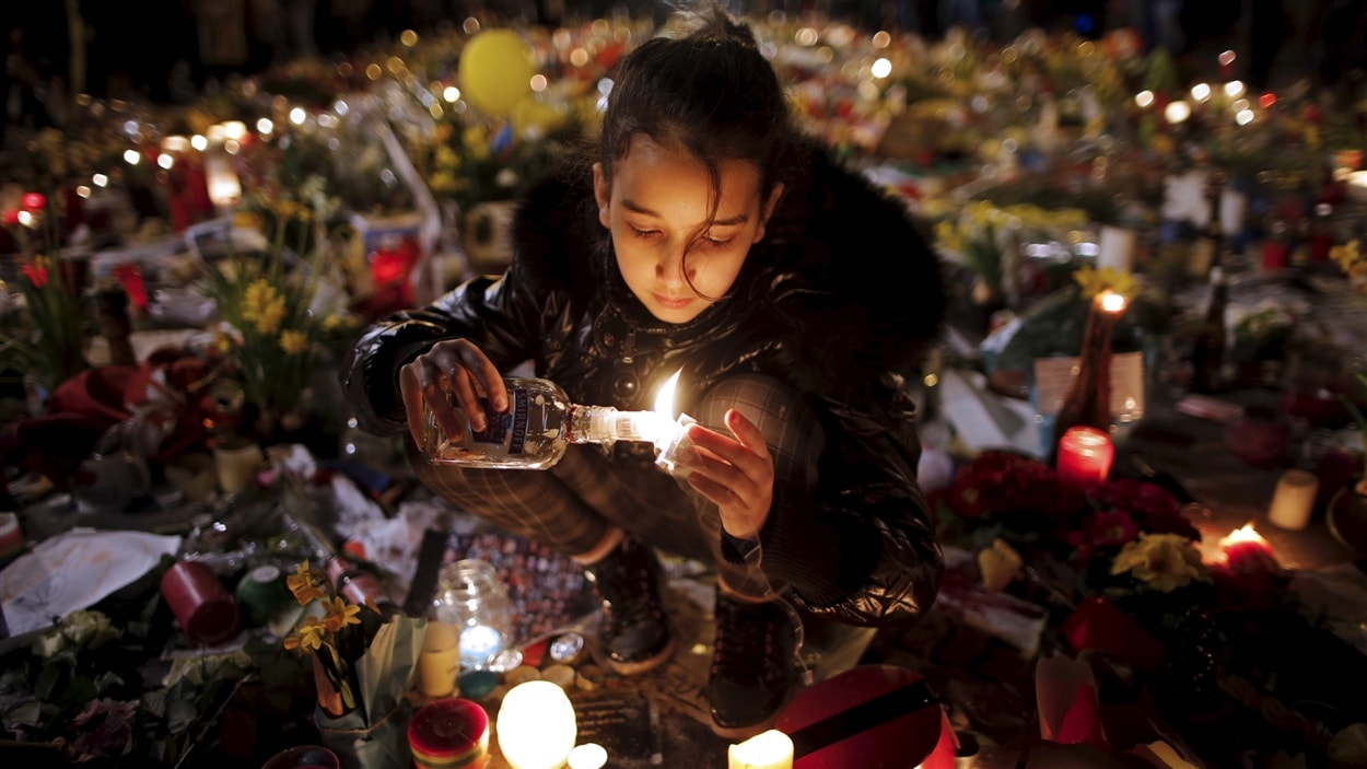 Une jeune fille allume un lampion à la Place de la bourse de Bruxelles en hommage aux victimes.
Une jeune fille allume un lampion à la Place de la bourse de Bruxelles en hommage aux victimes.