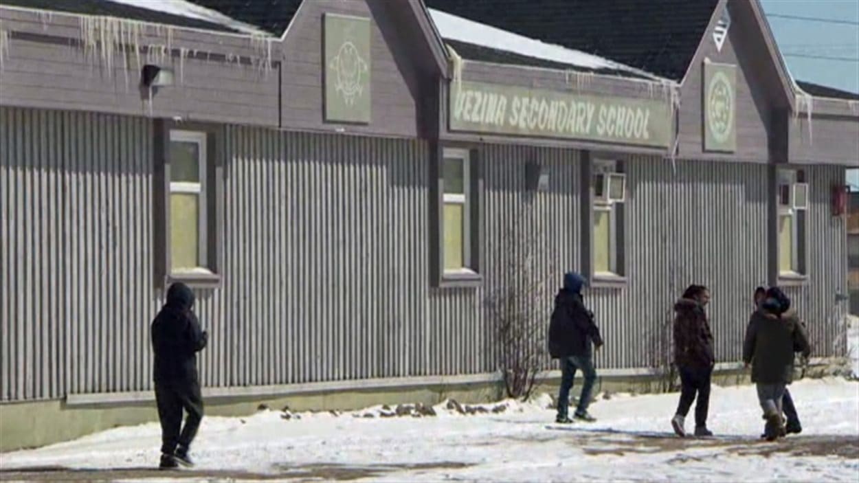 Des jeunes marchent à proximité de l'école secondaire à Attawapiskat. Des jeunes marchent à proximité de l'école secondaire à Attawapiskat.