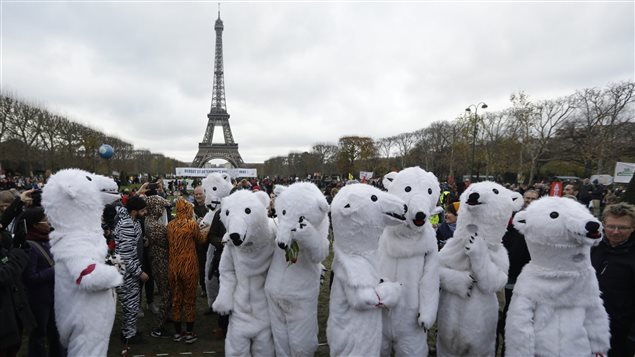 Des environnementalistes se sont rassemblés à Paris alors que les organisateurs du sommet sur le climat présentaient leur projet d'accord final en décembre 2015.