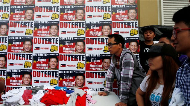 Des partisans de Rodrigo Duterte font la ligne pour obtenir des t-shirts de campagne, à la veille de l’élection, le 8 mai 2016, à Davao. Des partisans de Rodrigo Duterte font la ligne pour obtenir des t-shirts de campagne, à la veille de l’élection, le 8 mai 2016, à Davao.