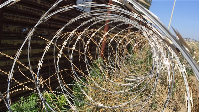 Des barbelés pour empêcher les gens de traverser le mur entre les États-Unis et le Mexique. Des barbelés pour empêcher les gens de traverser le mur entre les États-Unis et le Mexique.