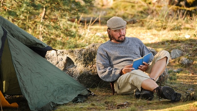 Un homme savoure un livre en forêt.