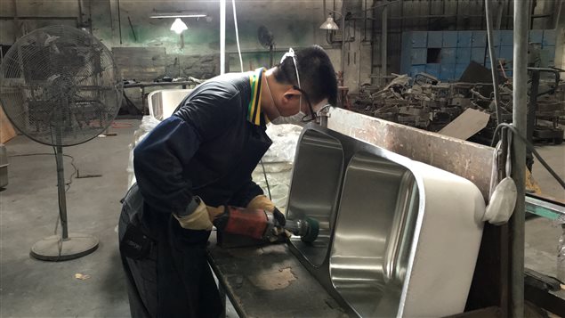 Un ouvrier chinois travaillant dans une usine d'éviers de Foshan. Un ouvrier chinois travaillant dans une usine d'éviers de Foshan.