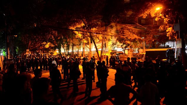 Des dizaines de gardes de sécurité encerclent le restaurant où une vingtaine de personnes sont prises en otage à Dacca, au Bangladesh. Des dizaines de gardes de sécurité encerclent le restaurant où une vingtaine de personnes sont prises en otage à Dacca, au Bangladesh.