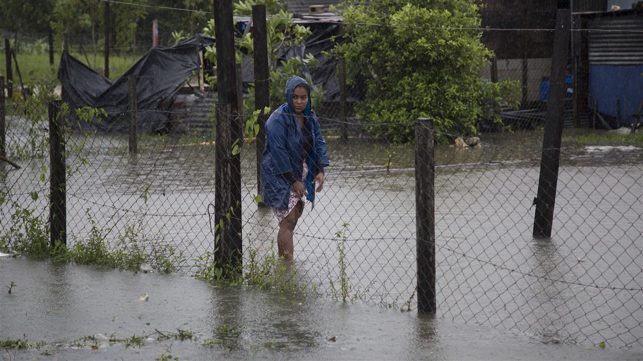 Une femme se promène dans des eaux de crues devant chez elle à Dolores, dans l'État guatémaltèque frontalier au Belize, le 4 août 2016. Une femme se promène dans des eaux de crues devant chez elle à Dolores, dans l'État guatémaltèque frontalier au Belize, le 4 août 2016.