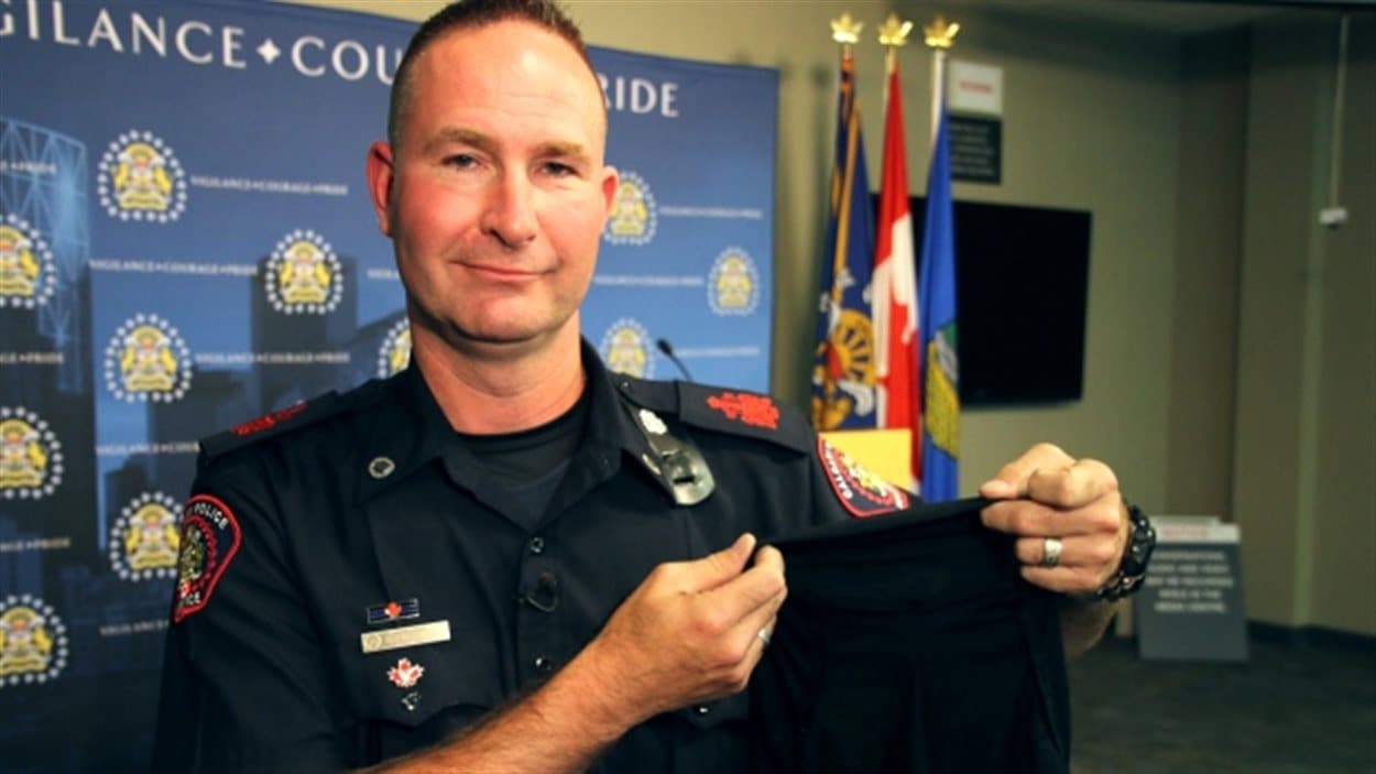 Le sergent major Rob Patterson du Service de police de Calgary a entre les mains un hijab spécialement conçu pour être porté avec l'uniforme. Le sergent major Rob Patterson du Service de police de Calgary a entre les mains un hijab spécialement conçu pour être porté avec l'uniforme.