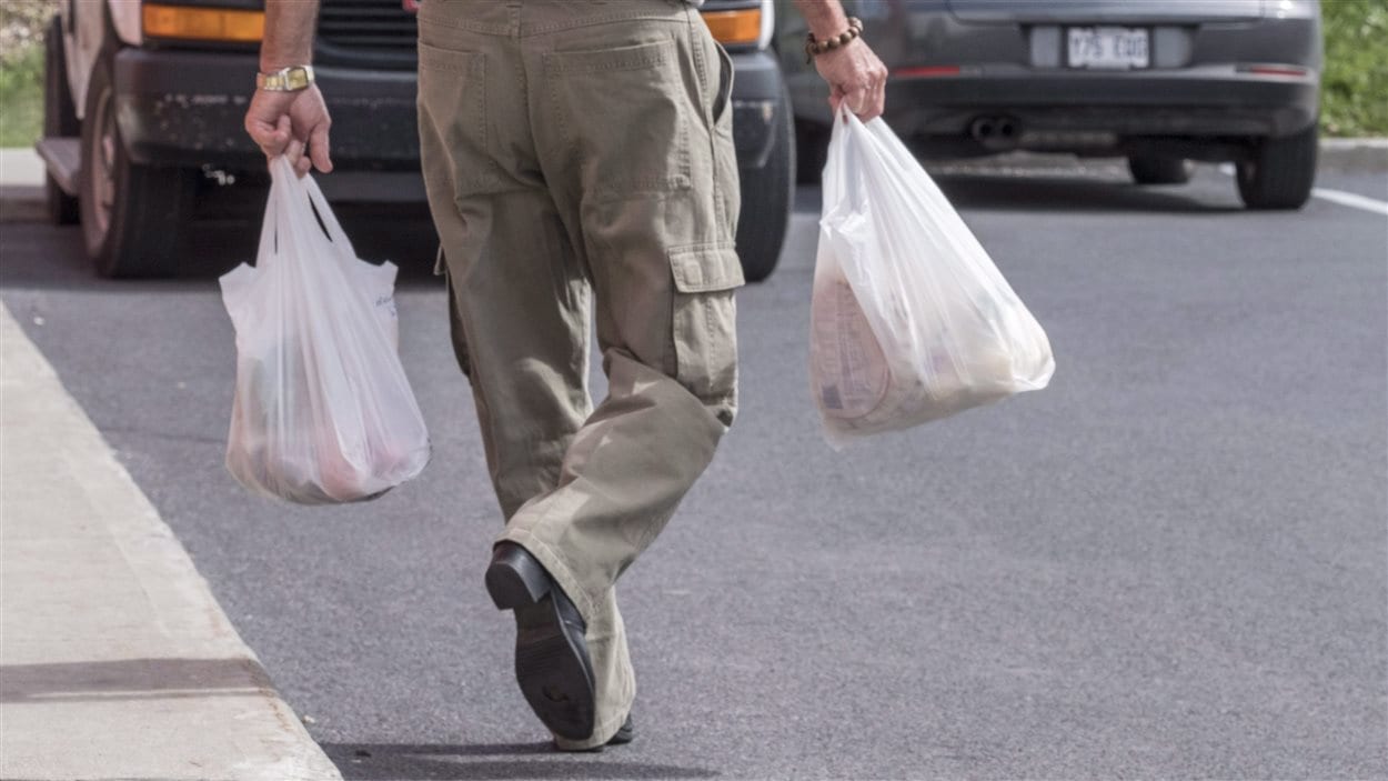 Un consommateur de Brossard transporte ses emplettes dans des sacs en plastique à usage unique, désormais interdits dans cette ville. Un consommateur de Brossard transporte ses emplettes dans des sacs en plastique à usage unique, désormais interdits dans cette ville.