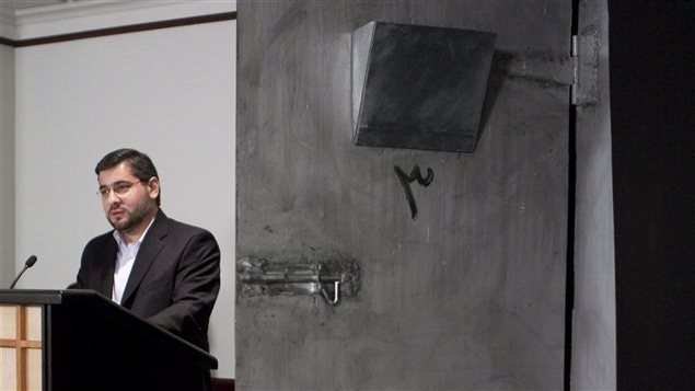 Abdullah Almalki à côté d'une reconstitution de sa cellule syrienne (2009) Abdullah Almalki à côté d'une reconstitution de sa cellule syrienne (2009)