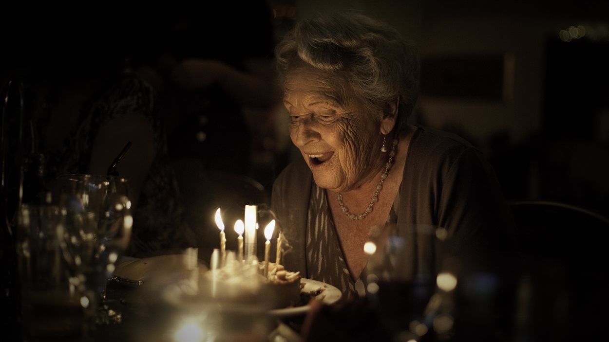 Une dame âgée souffle des bougies Une dame âgée souffle des bougies
