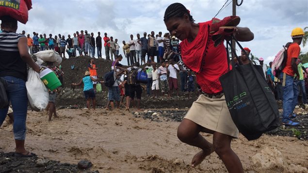 Une femme traverse à pied un cours d'eau à Petit-Goâve. Une femme traverse à pied un cours d'eau à Petit-Goâve.