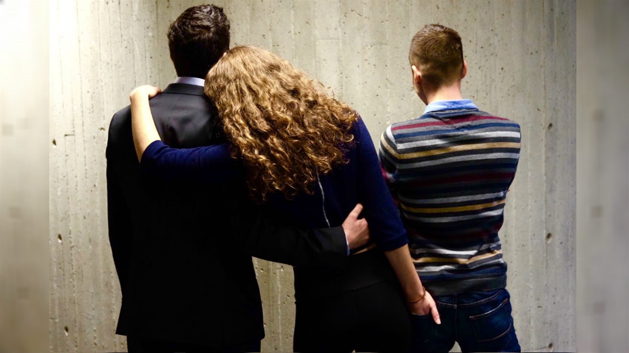 Une femme polyamoureuse enlace deux hommes Une femme polyamoureuse enlace deux hommes