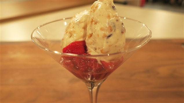 Une coupe contenant un parfait glacé et des fraises en garniture