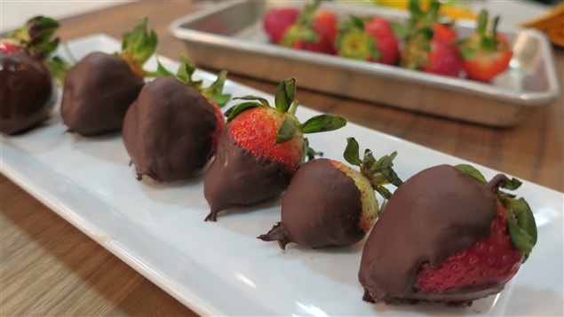 Un plateau de fraises recouvertes de chocolat