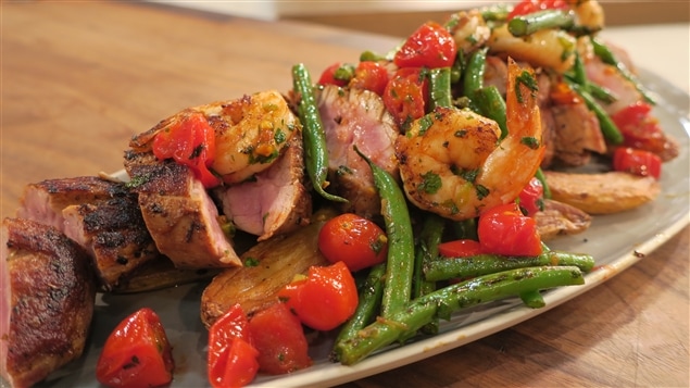 Un plat contenant du boeuf, des crevettes, des tomates et des haricots verts Un plat contenant du boeuf, des crevettes, des tomates et des haricots verts